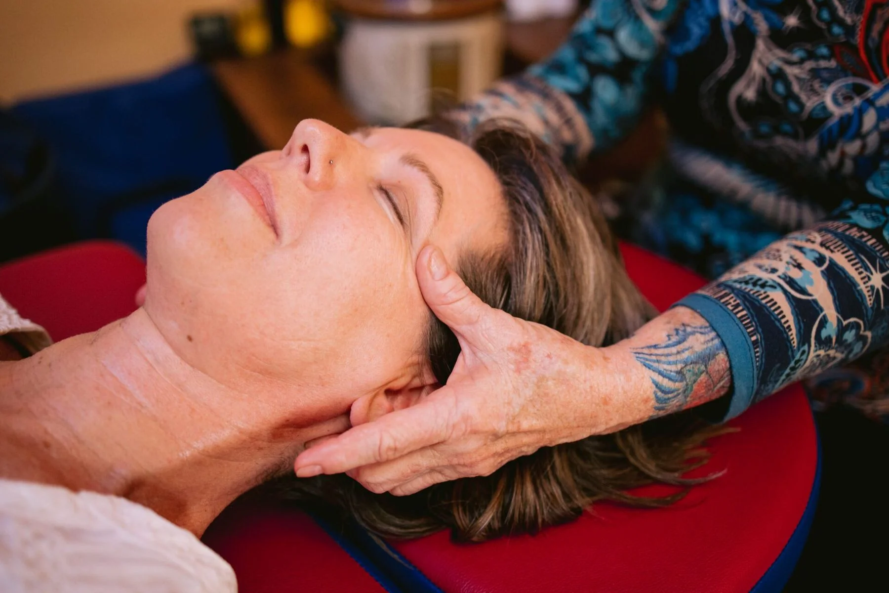 Maggie supporting a client's head during a gentle massage session